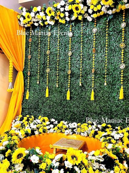 A high-angle shot of the grand Haldi setup, showing the urli surrounded by a bed of sunflowers and white flowers.