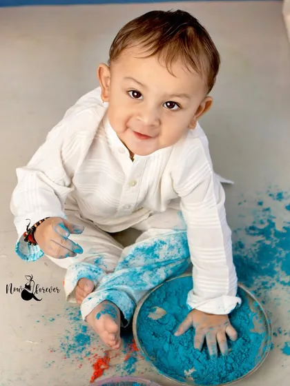 A little boy gets his hands messy with blue gulal. The simple white kurta makes the bright colors pop in this fun and dynamic Holi photo.
