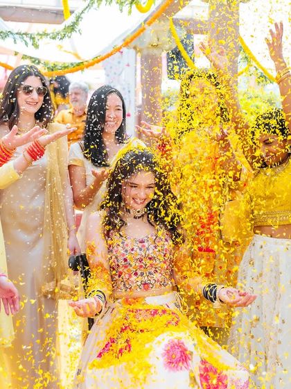 A wide shot of the bride's friends showering her with petals, capturing the full celebratory moment.