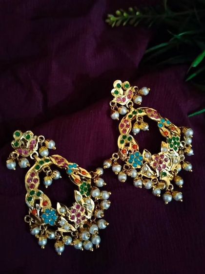 The earrings from the 'Triveni' set. These danglers are designed to match the intricate, multi-hued patterns of the layered necklace, ensuring a cohesive and stunning look.