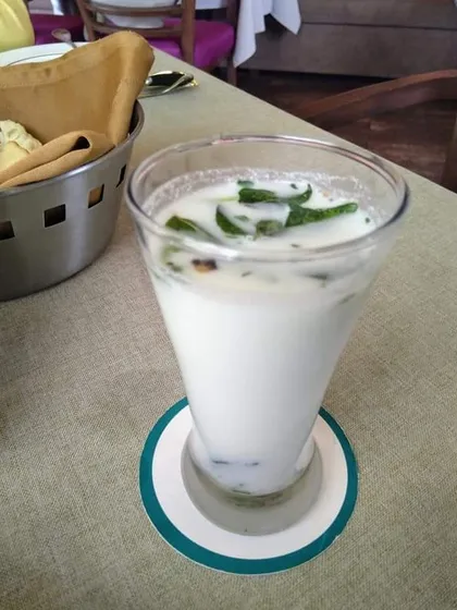 A tall glass of refreshing plant-based chaas or buttermilk. It's a cooling and digestive drink, perfect for pairing with a spicy Indian meal, made entirely from vegan ingredients.