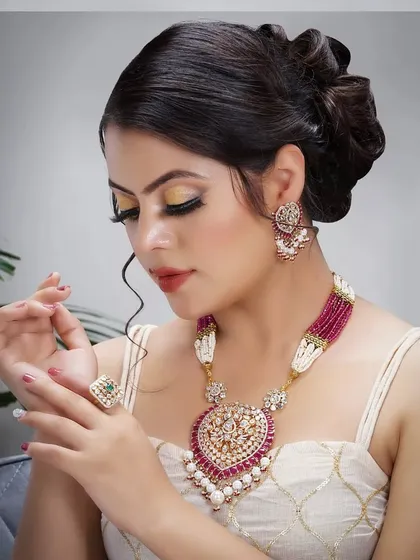 An intricate, woven updo designed for a commercial shoot featuring traditional jewelry. The hairstyle adds a touch of modern elegance while still feeling classic, perfectly framing the statement necklace.