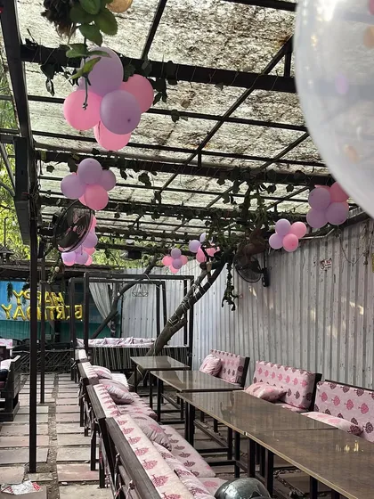 A view of the cafe's outdoor space, with balloon clusters adding to the festive decor.