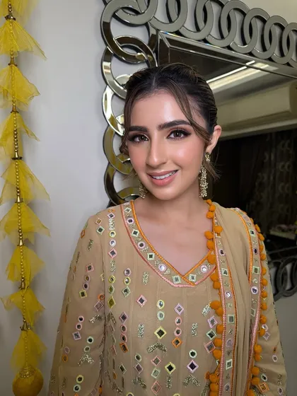 Even from the front, the high ponytail with face-framing tendrils creates a soft yet stylish look, perfect for a festive celebration like Diwali or a family puja.