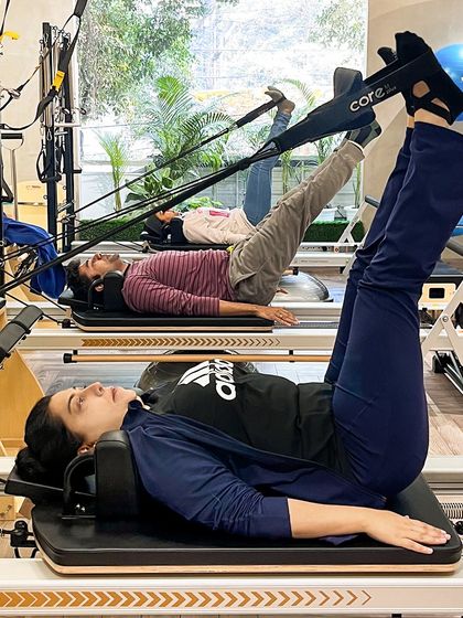 A symphony of focus and power. Our clients demonstrate strength and precision during a leg series on the Reformers.