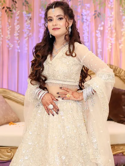 A full view of her elegant engagement outfit. The soft curls and minimal makeup create a sophisticated and graceful look.