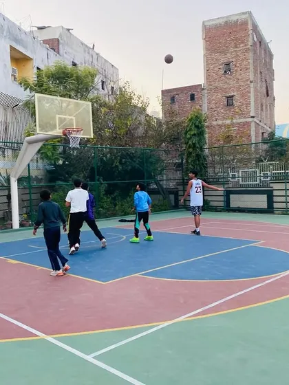 A player takes a long-range shot, practicing the range needed for modern basketball.