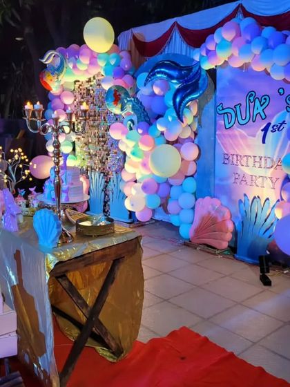 A side view of the mermaid party setup, showing the layers of decoration from the cake table to the backdrop.
