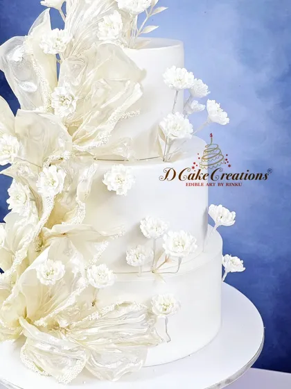 A closer view of the rice paper sail cake, highlighting the translucent texture of the sails and the intricate details of the small sugar flowers.
