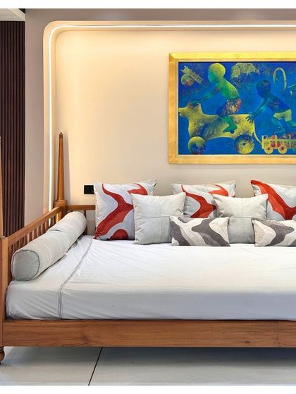 A close-up of the 'baithak' daybed, showcasing the clean lines of the woodwork and the vibrant cushions that add a pop of color. This space is a perfect example of how we tailor each area to the family's lifestyle.