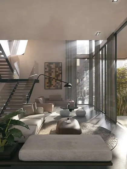 The interior of a Moira villa features an earthy, open-plan living space that merges seamlessly with the outdoor pool deck. Floor-to-ceiling glass walls and a continuous flooring material erase the boundary between inside and out.