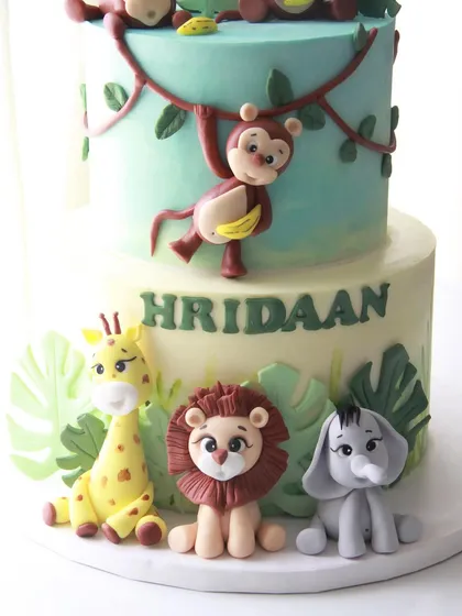 A closer look at the adorable, handcrafted fondant animals on the jungle cake, including a giraffe, lion, and elephant.