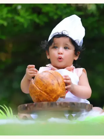 A close-up of our little chef interacting with props in a lush, green outdoor setting. The natural environment adds a fresh and vibrant feel to the photos.