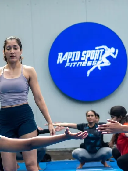 An instructor demonstrates a mobility exercise to the StrongHER group. Our workshops combine expert-led talks with hands-on movement sessions to provide a holistic learning experience.