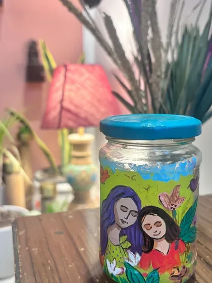 A small jar painted with a tender portrait of a mother and daughter, created during our special Mother's Day workshop.