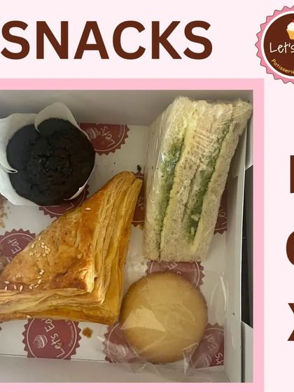 A classic snack box combination with a savoury puff, a chutney sandwich, a chocolate muffin, and a cookie. It offers a balanced mix of flavours and textures.