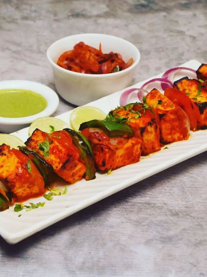 A plate of my classic Paneer Tikka, beautifully arranged and ready to eat. The paneer is grilled until it has a slight char, giving it a smoky flavour that pairs perfectly with the fresh mint chutney.