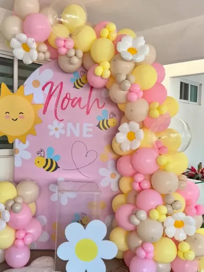 How sweet is this "Our Little Sunshine" first birthday theme? I used pastel pink and yellow balloons, daisy and bee accents, and a personalized backdrop for a cheerful celebration.