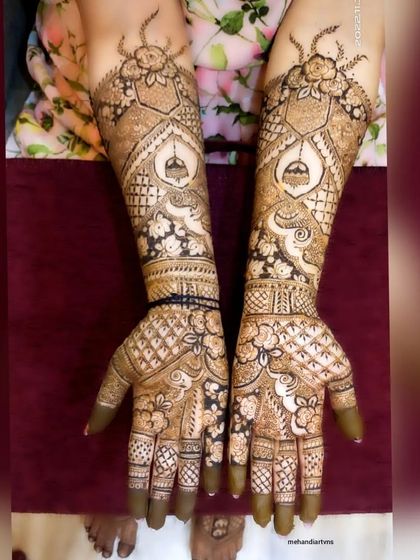 A beautiful and complex design featuring hanging temple bells (jhumkas) and swirling peacock-inspired patterns.