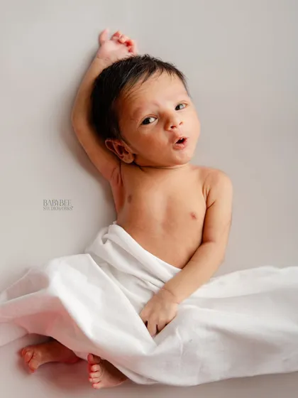 We also love capturing newborns when they are awake and expressive. This little one, resting on a simple white backdrop, gave us a wonderful, curious look that shows off their budding personality.