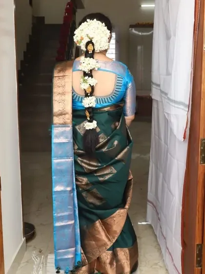This is a classic South Indian hairstyle featuring a traditional braid, beautifully decorated with fresh jasmine flowers, or 'malli poo'. It's an elegant choice that perfectly complements a silk saree for any wedding or festive function.