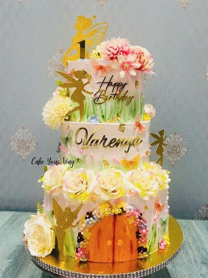 A three-tier fairy garden cake, where magic meets sweetness. This showstopper is perfect for a grand first birthday celebration.