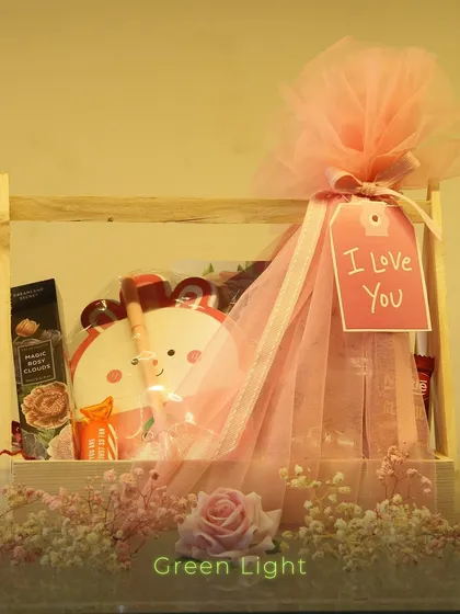 A sweet and simple gift in a wooden crate. This hamper features a cute bear-themed item and is wrapped in pink tulle with an "I Love You" tag.