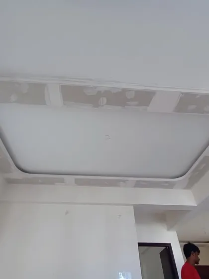 This image shows the initial stage of a false ceiling installation. Our team has created the framework and is preparing the surface for the final plastering and lighting fixtures.