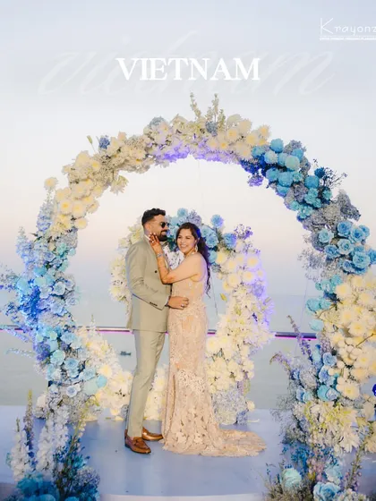 A stunning wedding setup in Vietnam, with a floral arch of blue and white hydrangeas overlooking the water. We find the most picturesque locations for your special day.