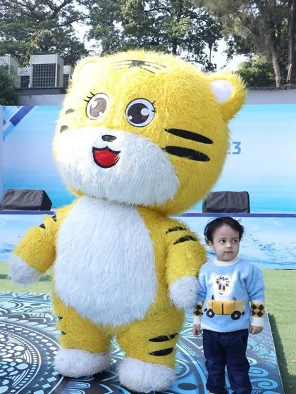 Even the littlest guests love our mascots. A toddler stands with our big, friendly tiger character at a family day event.