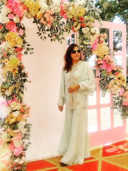 A beautiful floral archway makes for a perfect photo spot. My elegant outfit complements the romantic decor.