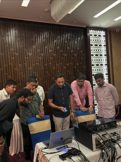 Collaboration is key to learning. During a practical session, our instructor guides attendees as they analyze calibration data on a laptop, using professional equipment to understand how to optimize an audio system in real-time.