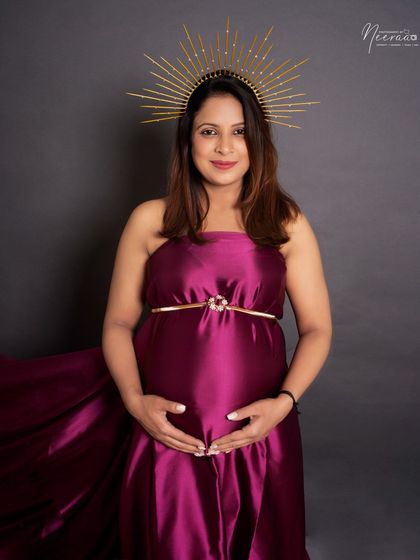 A simple, beautiful portrait focusing on the connection between mother and baby. Her hands cradling the bump and the serene halo create a feeling of peace.
