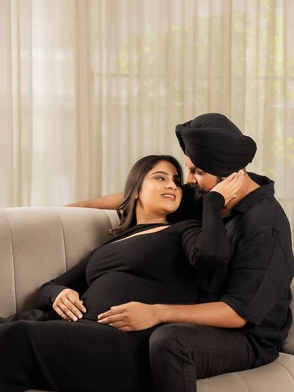 An intimate moment on the couch. This photo captures the couple's close bond and affection in the comfort and privacy of their own home.