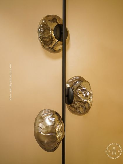 This vertical fixture features textured, moon-like chrome orbs attached to a central black rod. It's a striking, artistic piece that works well in corners or narrow spaces, adding a touch of celestial-inspired modernism.