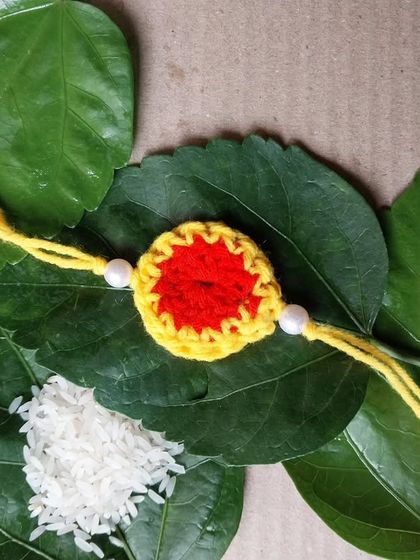 A red and yellow circular rakhi. These simple designs are perfect for bulk orders.