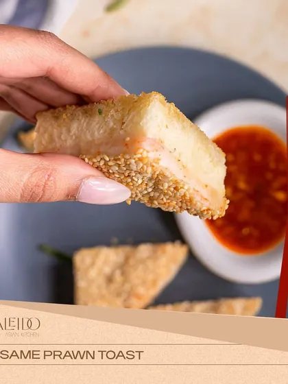 A close-up of my sesame prawn toast, showing the crisp, golden-brown texture of the sesame seed crust. It's served with a sweet chili dipping sauce for the perfect bite.