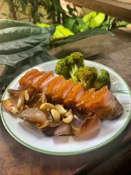 A simple, rustic plate of our crispy pork belly with sautéed shallots and garlic. This dish represents our core philosophy: honest, flavorful food made with care, just like we would at home in Coorg.