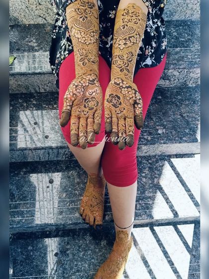 A full view of the rose-themed bridal henna, including matching designs on the feet.