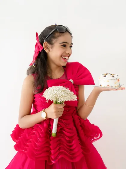 A candid, happy moment from the birthday shoot, where the girl is holding a bouquet of flowers and laughing.