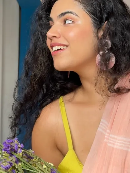 The perfect side profile, catching that golden hour light. This look features a peach saree with a lime green top, a color combination that is unexpected but works so well for a summer festive event.