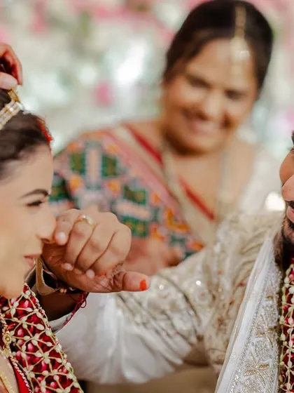A sweet, candid moment of the groom wiping away a bit of sindoor. These unscripted interactions are what make a wedding story unique and beautiful.