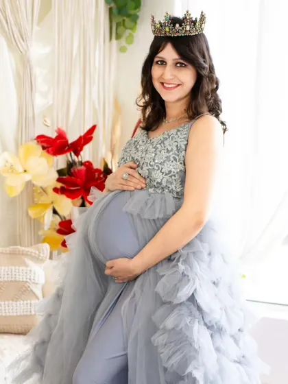 A happy and bright portrait of a mom-to-be in a silver and blue gown. This image highlights the detailed sequin work on the bodice and the soft tulle skirt.