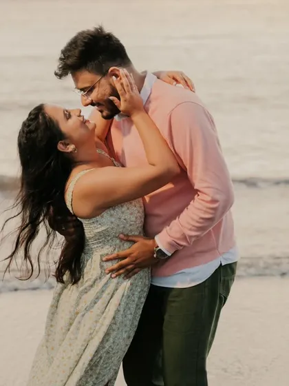 A joyful and candid moment of a couple laughing and embracing on the beach. This photo perfectly captures the fun and carefree spirit of their relationship.