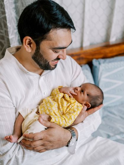 A father's loving hold. This lifestyle shot was taken during a naming ceremony, a perfect opportunity to capture those early newborn features before they change so quickly.