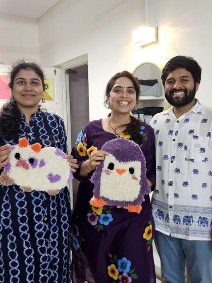 A family proudly showing off the adorable animal-themed rugs they made. My workshops are a great activity for a family outing.