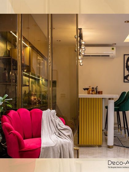 Experience the art of refined living. This corner, with its vibrant pink scalloped armchair and elegant bar area, is crafted to perfection, showcasing a bold yet sophisticated aesthetic.