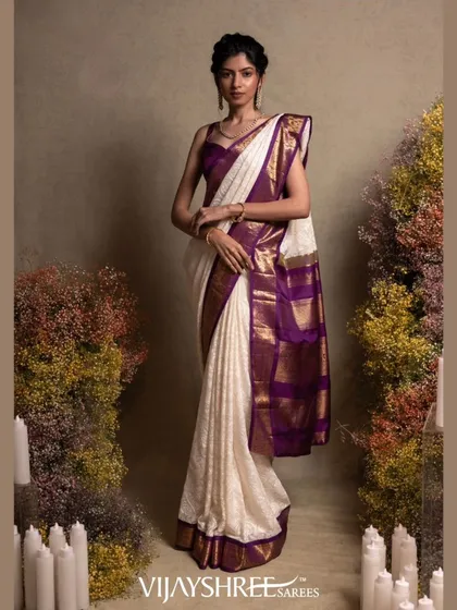 We blend tradition with personal style. This elegant white Kanjivaram silk saree is elevated with a rich purple border and exquisite, custom Chikankari hand embroidery, creating a unique masterpiece for a discerning bride.