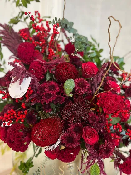 A closer look at the textures in this all-red arrangement. The unique shapes of the Banksia and Pincushion flowers add an exotic touch to the classic holiday palette.