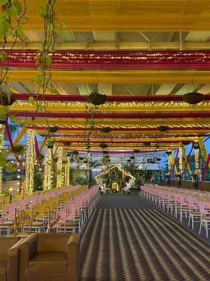 A vibrant Mehendi or Sangeet setup on the Sky Terrace, with colorful drapes in yellow and pink creating a festive atmosphere.